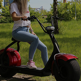 two fatbikes or electric scooters in the grass