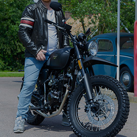 A person sitting on a retro-like moped