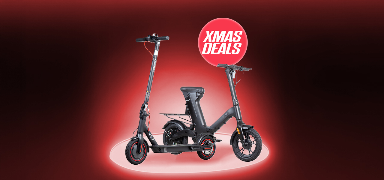 Man st&aring;r p&aring; en elsparkcykel p&aring; en stig omringad av natur