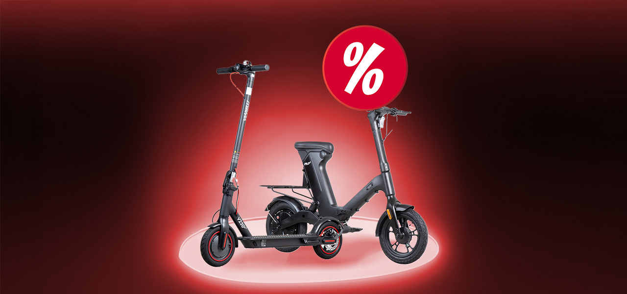 Man st&aring;r p&aring; en elsparkcykel p&aring; en stig omringad av natur